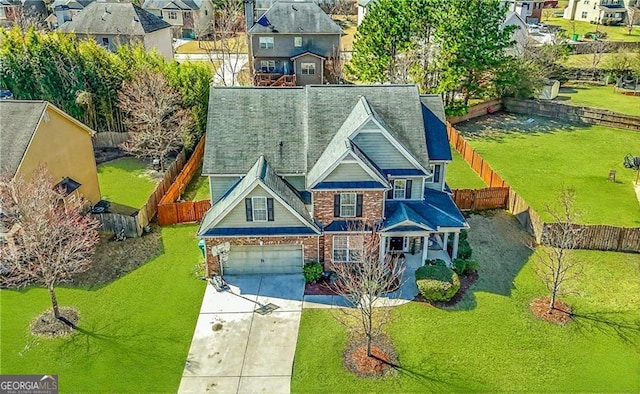 exterior space with brick siding, concrete driveway, fence, a residential view, and a front lawn