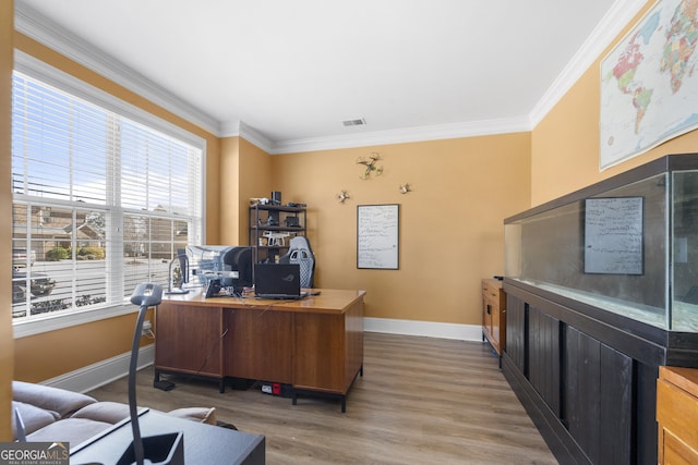 home office featuring baseboards, wood finished floors, visible vents, and crown molding