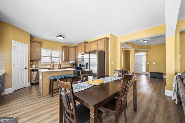 dining space with baseboards and wood finished floors