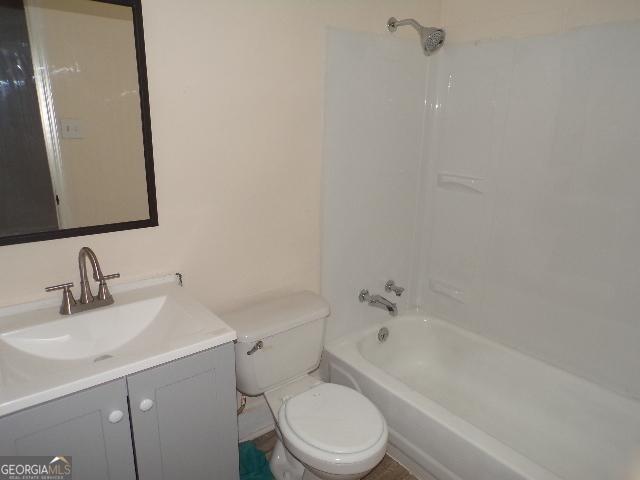 full bath with vanity, shower / tub combination, and toilet