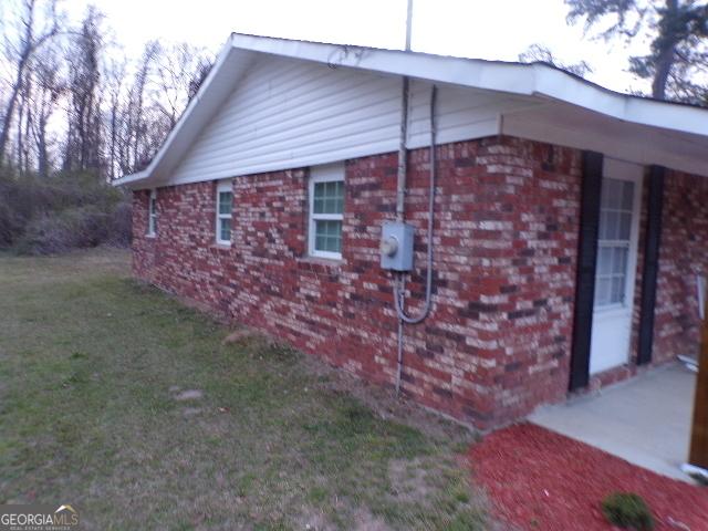 view of property exterior featuring a lawn and brick siding