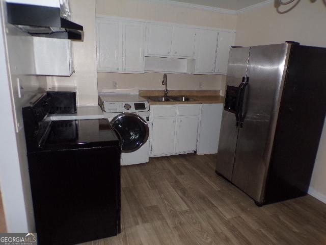 kitchen with white cabinets, a sink, wood finished floors, washer / dryer, and stainless steel fridge with ice dispenser