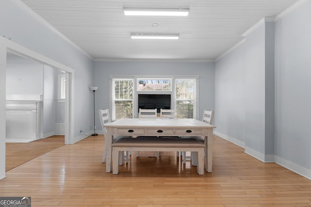 dining room featuring ornamental molding, light wood-type flooring, and baseboards