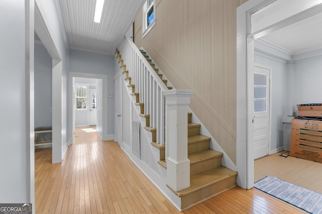 stairs with crown molding and hardwood / wood-style floors