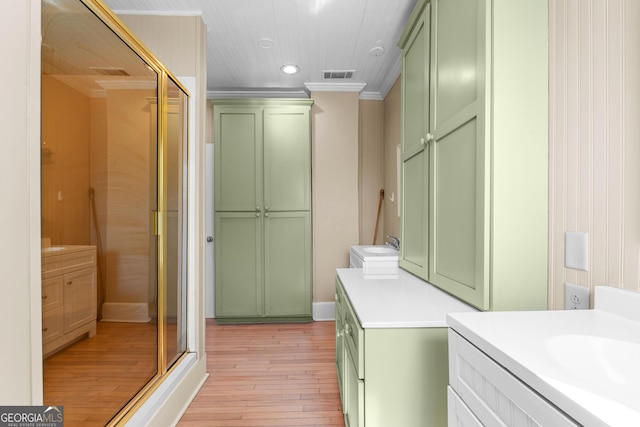 bathroom featuring a stall shower, visible vents, crown molding, and hardwood / wood-style floors