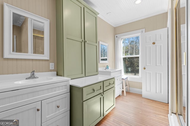 bathroom with crown molding, hardwood / wood-style floors, and vanity