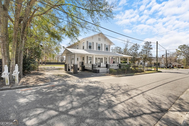 farmhouse inspired home featuring a porch, metal roof, and fence