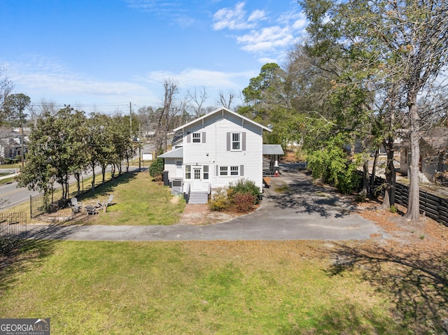 view of side of home with a yard and fence