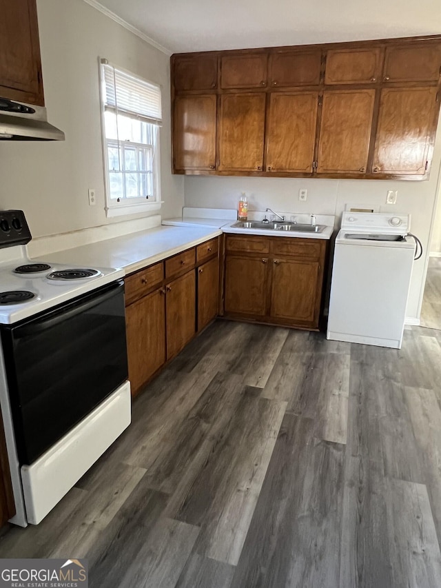 kitchen with under cabinet range hood, electric stove, light countertops, brown cabinetry, and washer / dryer