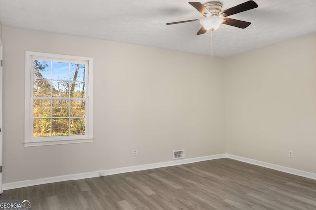 spare room featuring visible vents, ceiling fan, a textured ceiling, wood finished floors, and baseboards