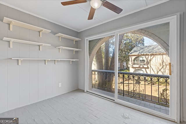 interior space featuring a ceiling fan and crown molding