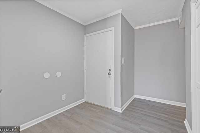 spare room with baseboards, wood finished floors, and crown molding