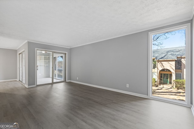 unfurnished living room featuring a wealth of natural light, dark wood-style flooring, a textured ceiling, and baseboards