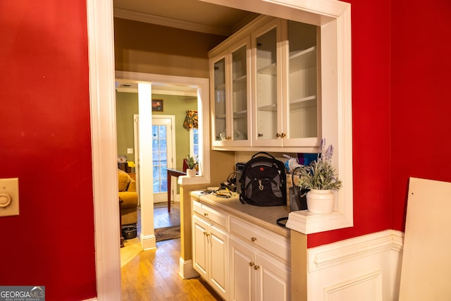 bar with crown molding, light wood-style flooring, and baseboards