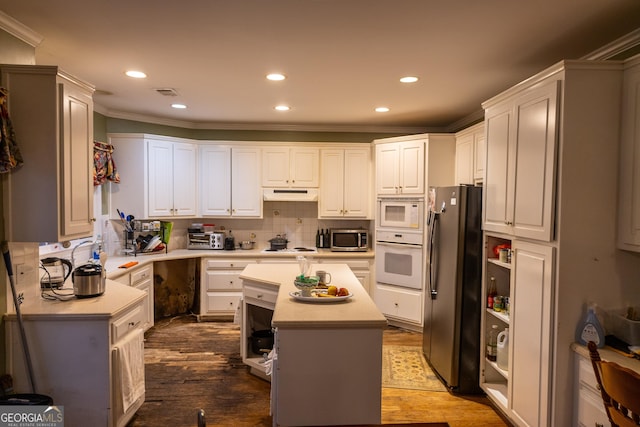 kitchen with light countertops, appliances with stainless steel finishes, decorative backsplash, and under cabinet range hood