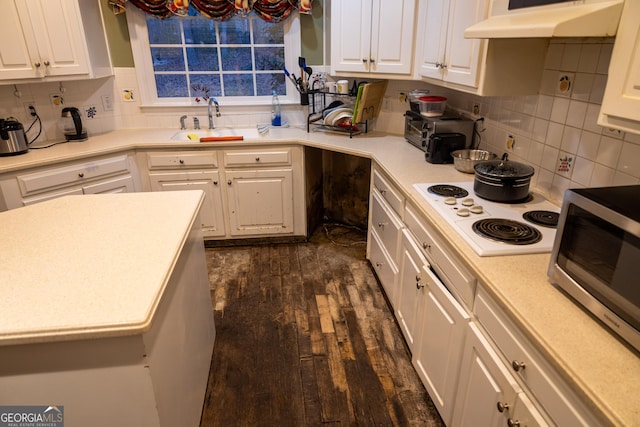 kitchen featuring under cabinet range hood, a sink, white cabinetry, white electric cooktop, and stainless steel microwave