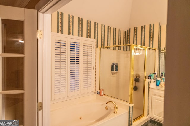 bathroom featuring a stall shower, a garden tub, and wallpapered walls