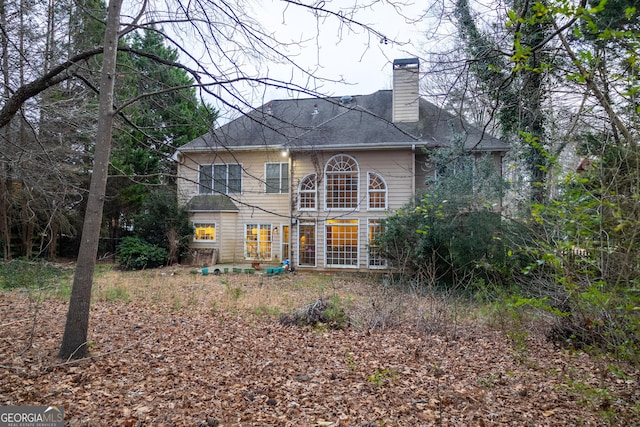 rear view of house featuring a chimney