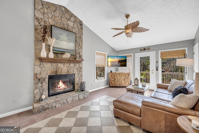 living room with tile patterned flooring, vaulted ceiling, a textured ceiling, and a stone fireplace