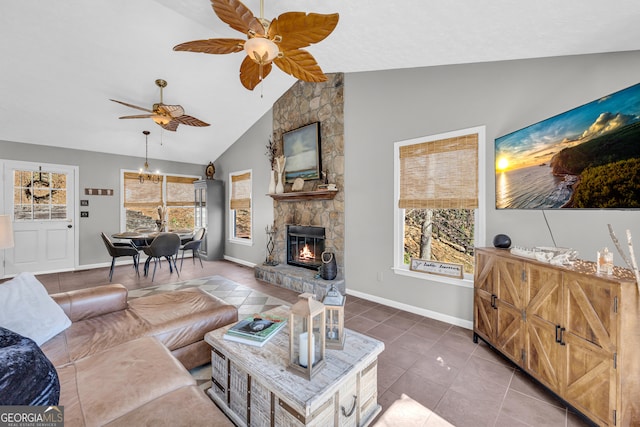 tiled living area with high vaulted ceiling, ceiling fan, a fireplace, and baseboards