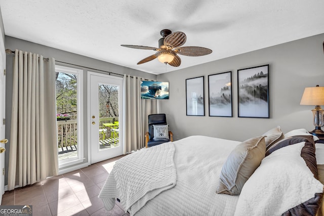 bedroom with access to exterior, tile patterned flooring, ceiling fan, and a textured ceiling