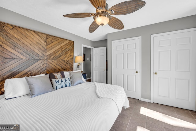 tiled bedroom with a ceiling fan and baseboards