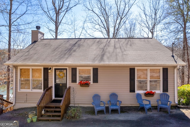 view of front facade featuring a chimney and a patio area