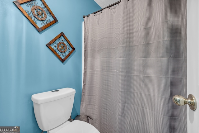 full bath featuring a shower with shower curtain and toilet