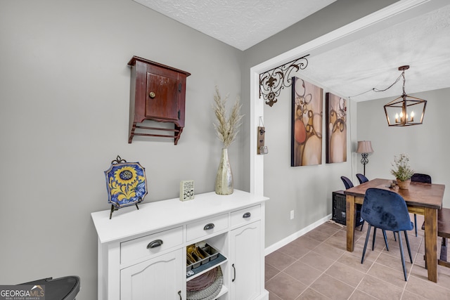 interior space with baseboards, a chandelier, a textured ceiling, and light tile patterned flooring