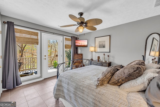 bedroom with access to exterior, visible vents, ceiling fan, a textured ceiling, and tile patterned flooring