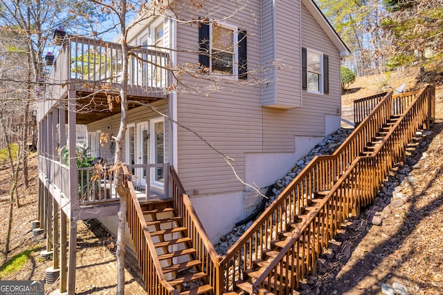 view of home's exterior with stairway and a wooden deck