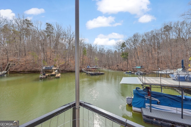 dock area featuring a forest view and a water view