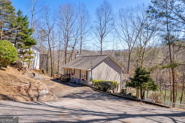 view of front of home with driveway and fence