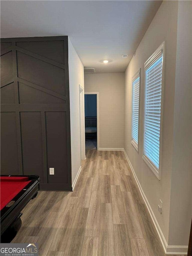 interior space with light wood-style floors, visible vents, and baseboards