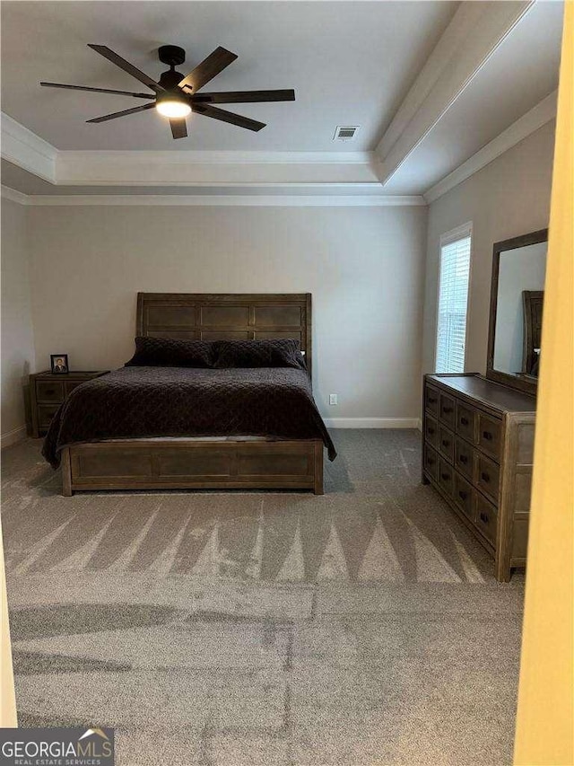 bedroom featuring visible vents, baseboards, carpet, a raised ceiling, and crown molding