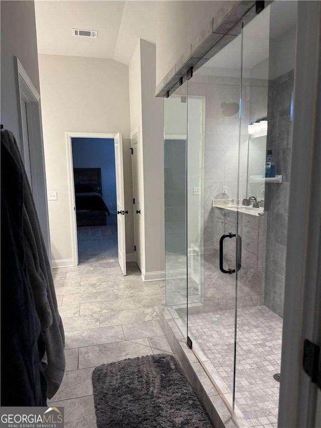 full bathroom with a stall shower, baseboards, visible vents, lofted ceiling, and ensuite bath