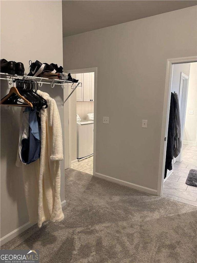 spacious closet featuring washer and dryer and light colored carpet