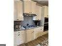 kitchen with tasteful backsplash, cream cabinets, and gas cooktop