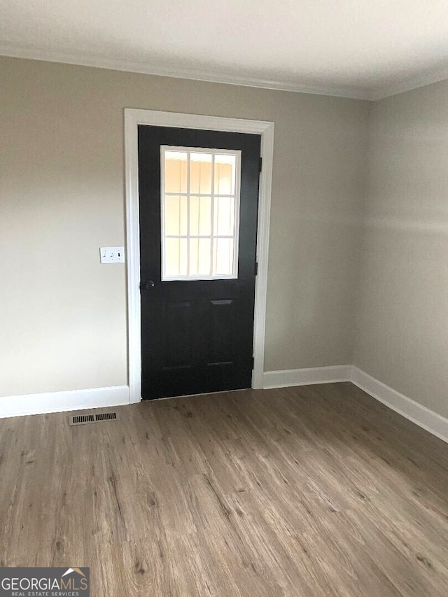 646 Enterprise St, Swainsboro, GA 30401 - foyer entrance with ornamental molding, visible vents, baseboards, and wood finished floors