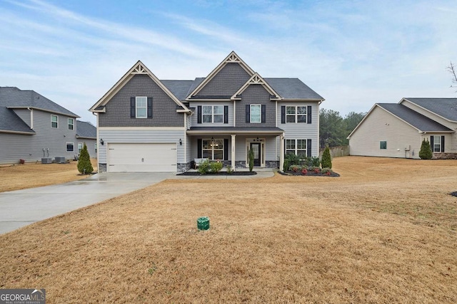 craftsman-style home with covered porch, driveway, a front lawn, and an attached garage