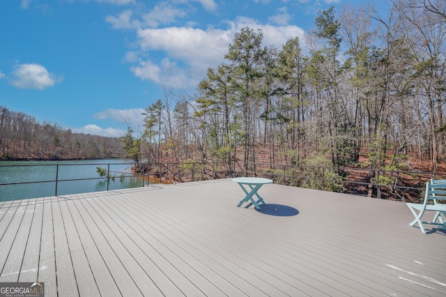 wooden deck featuring a water view and a wooded view