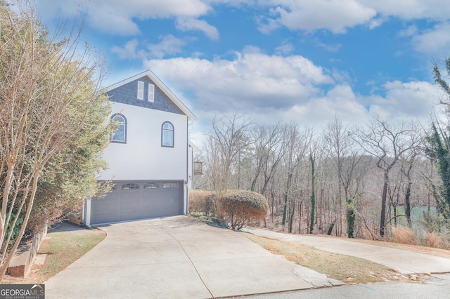 view of side of property with an attached garage and driveway