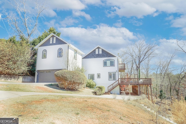 view of front of house with stairway, an attached garage, a front yard, a deck, and driveway