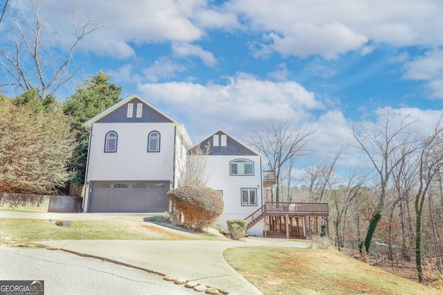 view of front facade with stairs, driveway, an attached garage, and a front yard