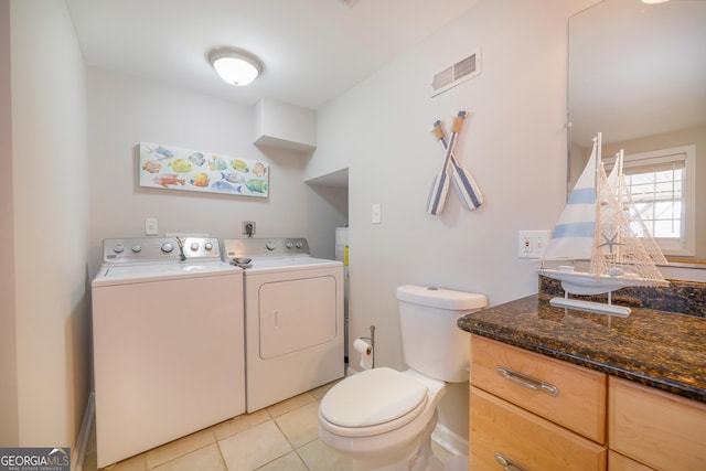 interior space featuring light tile patterned floors, laundry area, visible vents, and separate washer and dryer