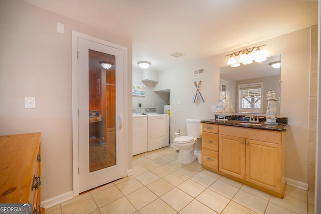 bathroom with visible vents, baseboards, tile patterned flooring, vanity, and separate washer and dryer