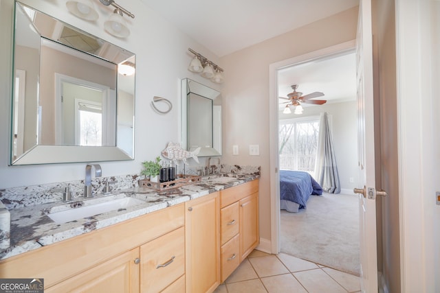 ensuite bathroom with tile patterned floors, a sink, baseboards, and double vanity