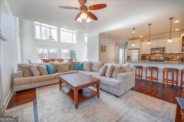 living area featuring hardwood / wood-style flooring, crown molding, a ceiling fan, and recessed lighting