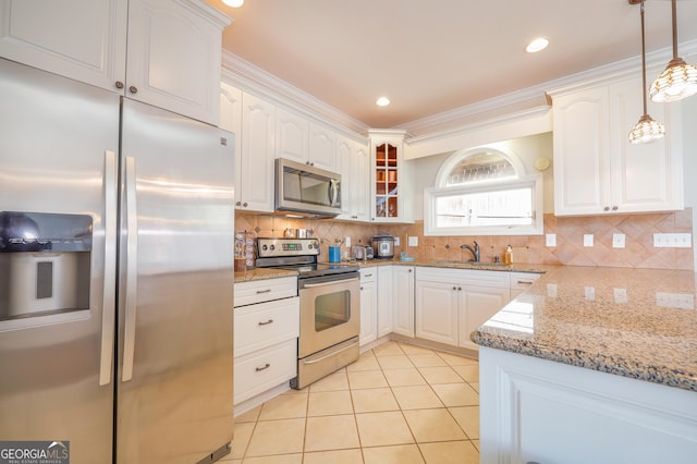 kitchen with light tile patterned floors, appliances with stainless steel finishes, white cabinets, and a sink