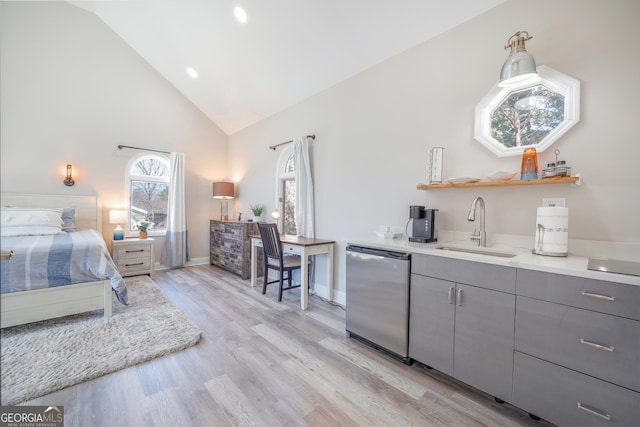 bedroom featuring baseboards, light wood-style flooring, high vaulted ceiling, and a sink